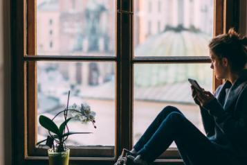 Woman alone at home looking out of the window