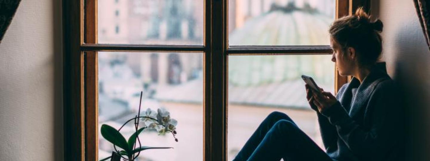 Woman alone at home looking out of the window
