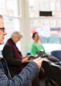 Man in waiting room looking at a mobile phone